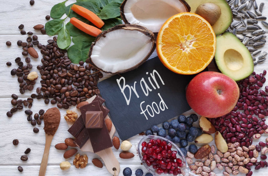 A variety of healthy foods, including a brain-shaped vegetable, with the words 'brain food' written above. The concept of eating these foods to support brain health and cognitive function is depicted.