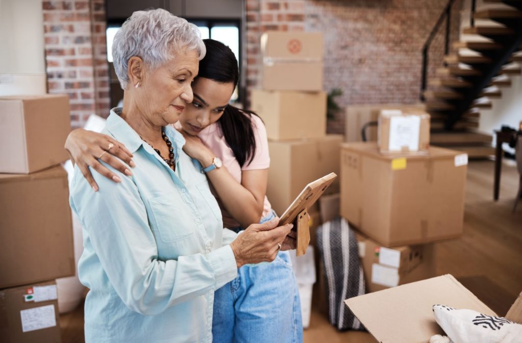 An adult child helps their parent pack for their move to assisted living.