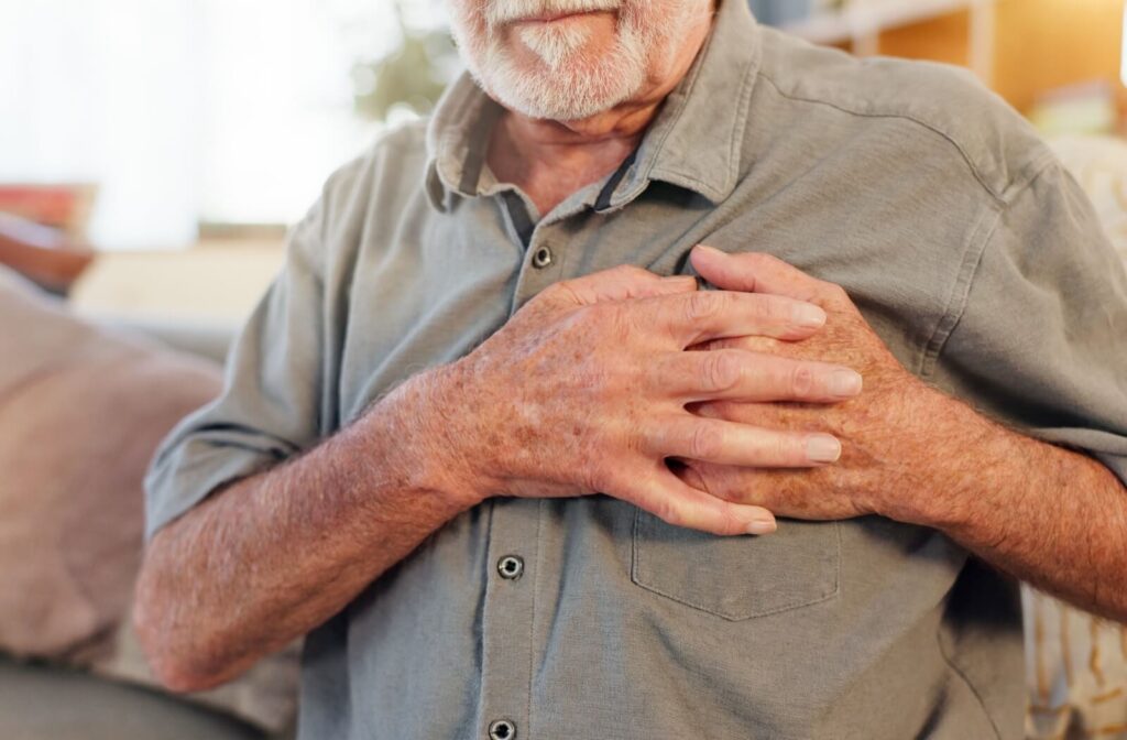a senior man close up putting his hands on top of his heart