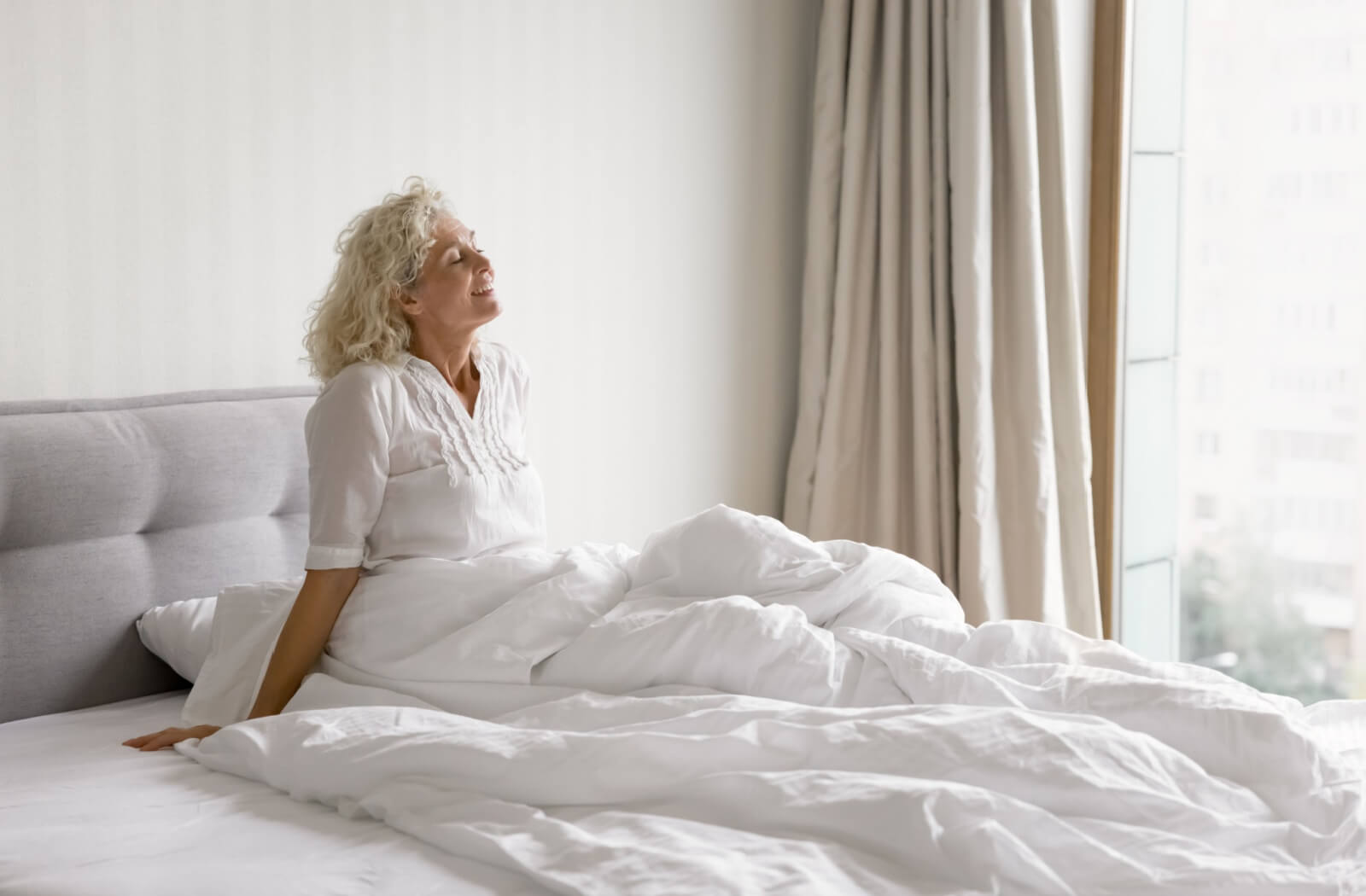 Someone wakes up from a good sleep, appearing well rested and ready for their day.